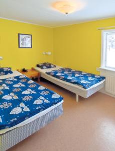 BlattnikseleHoliday home - Semesterhus Solnedgång的黄色墙壁客房的两张床