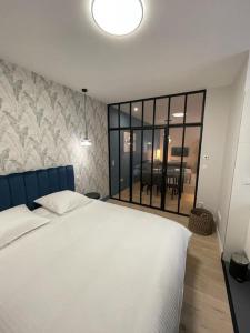 里昂Appartement pour 1à2 personnes#2的卧室设有白色的床和大窗户