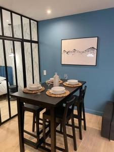 里昂Appartement pour 1à2 personnes#2的一张带椅子的餐桌和蓝色的墙壁