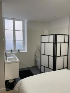 里昂Appartement pour 1à2 personnes#2的白色卧室设有床铺和水槽