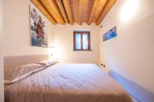 维托里奥·威尼托Residence Porta Della Muda的一张位于带木制天花板的客房内的大床