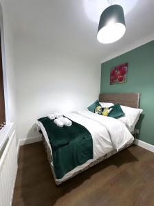 伦敦Md Stays的一间卧室配有一张带绿色和白色棉被的床