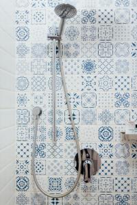 第聂伯罗Капсульний готель Добрий sleep&eat的浴室铺有蓝色和白色瓷砖,设有淋浴。