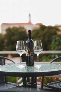 米库洛夫Pension Štěpán的一张桌子上摆放着一瓶葡萄酒和两杯酒杯