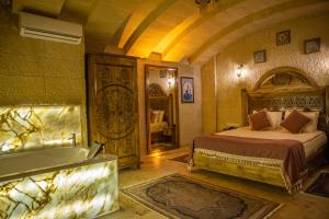 格雷梅Garden Suites Hotel Cappadocia的卧室配有床和浴缸
