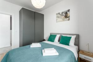 华沙Warsaw City River View的一间卧室配有一张带绿色和白色床单的床