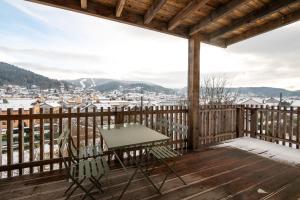 热拉梅K1, appartement avec grande terrasse et vue pistes的观景甲板上的桌椅