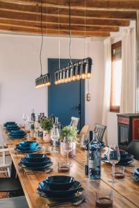 MontagutCan Riera de Montagut - Masia per 20 persones的长木桌,带蓝色的盘子和玻璃杯