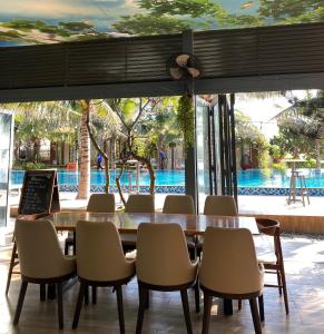 隆海安和公寓酒店的一间带桌椅的用餐室和一个游泳池