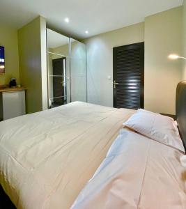 MontjolyL'Eskale Guyane的卧室配有一张带镜子的白色大床