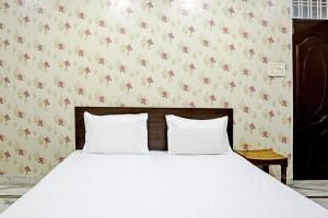 乌代浦OYO 82032 The Gunjan Villa Palace的卧室内的一张带两个白色枕头的床