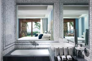 陶尔米纳拉普拉吉度假酒店的一间带浴缸和大镜子的浴室