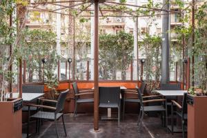 略夫雷加特河畔奥斯皮塔莱特马达尼斯酒店的一间设有桌椅和树木的餐厅