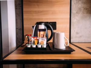 贝尔法斯特宜必思贝尔法斯特市中心酒店的咖啡壶和桌子上的杯子