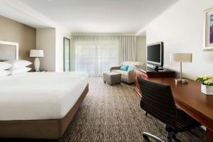 纽波特海滩新港海滩凯悦酒店的大型酒店客房设有一张大床和一张书桌