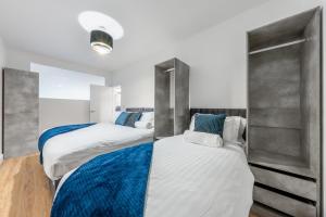 波特斯巴Modern Stylish 2 bedroom apartment in the heart of Potters Bar的白色和蓝色的客房内的两张床