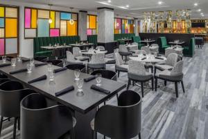 萨拉索塔DoubleTree by Hilton Sarasota Bradenton Airport的餐厅设有桌椅和色彩缤纷的墙壁
