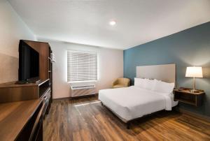 罗克雷治WoodSpring Suites Rockledge - Cocoa Beach的一间卧室配有一张床和一台平面电视