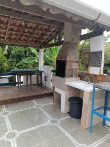陶巴特Chácara das Pedras的一个带烧烤架和桌子的户外厨房