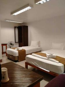 碧瑶Skyland Garden Hotel and Resort的酒店客房设有两张床和一张桌子。
