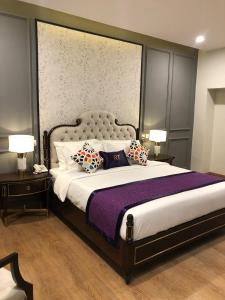 卡拉尔哥特RT Grace Royal Taj Hotel Sukkur的一间卧室配有一张大床和枕头