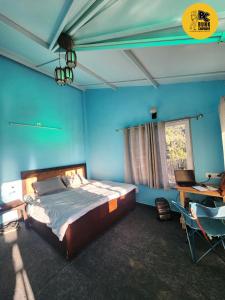 穆克缇斯瓦BUNK CHAMBER的一间卧室设有蓝色的墙壁、一张床和一张书桌