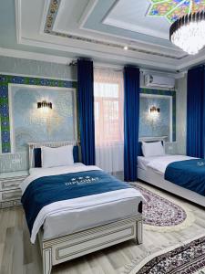 撒马尔罕Diplomat Premium Hotel的一间卧室设有两张带蓝色窗帘的床和天花板