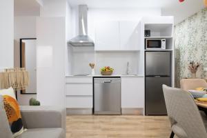 瓦伦西亚DormForYou Arena Delux的厨房配有白色橱柜和不锈钢冰箱