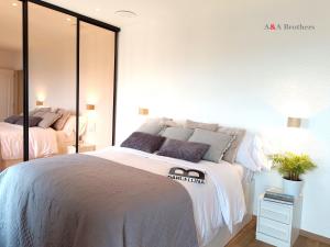 萨卡罗A&A Brothers S'Agaró Bay的一间卧室配有两张床和镜子