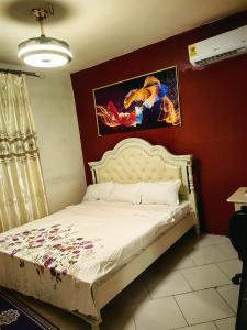 阿克拉hongyuanprimierhotel的卧室配有白色的床铺和红色的墙壁