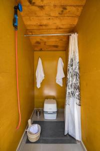 锡谢尔特Stay Wilder Sunshine Coast的黄色墙壁上的小浴室设有卫生间
