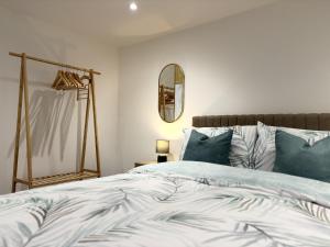 阿尔弗斯顿Hardy Hideaway的一间卧室配有一张带蓝色枕头和镜子的床