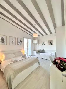 塞拉尔朱斯Villa Noga Rooms的白色卧室设有一张大床和一张沙发