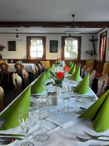 巴登-巴登温伯格餐厅酒店的用餐室配有带酒杯的长桌