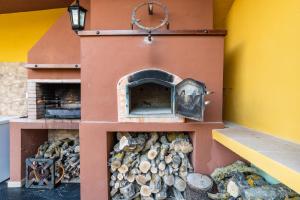 格拉纳达Casa Rural "compartida" La Loma的一个带一堆木柴的户外烤箱