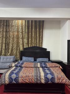 伊斯兰堡Islamabad lodges apartment suite的一间卧室配有一张带五颜六色棉被的床