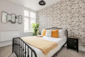 伯恩茅斯Sea Breeze Apartments的一间卧室设有一张床和砖墙