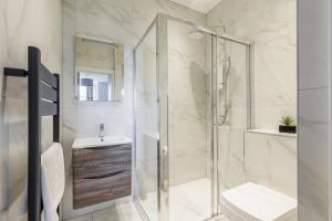 伯恩茅斯Sea Breeze Apartments的带淋浴、卫生间和盥洗盆的浴室
