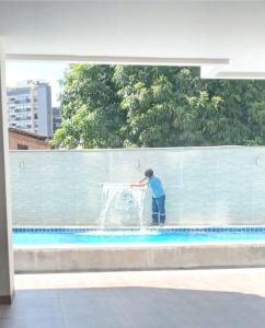 圣克鲁斯Downtown Apartments "Altos del Sur"的一个人在游泳池的喷泉里玩耍