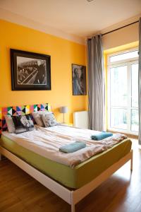 华沙佩佩旅馆的一间卧室设有一张黄色墙壁的大床