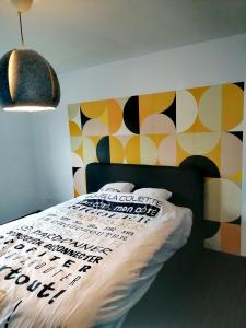 FloreffeLa Citronnade的一间卧室配有一张带图案墙壁的床