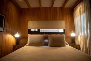 圣马丁德洛斯RentUp - Vistas panoramicas y comodidades de lujo, Vila Master的一间卧室配有带2个枕头和2盏灯的床