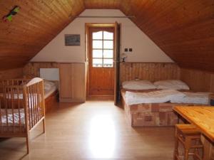 小莫拉夫卡Domeček Karlov的阁楼卧室设有两张床和窗户。