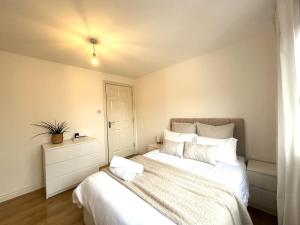 格拉斯哥Private room with en-suite and parking in shared flat的一间卧室配有一张带白色床单的大床