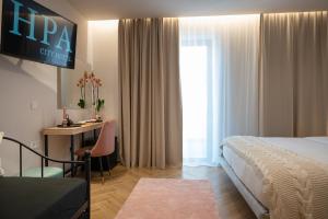 卡拉马塔IRA - ΗΡΑ City Hotel的配有一张床和一张书桌的酒店客房