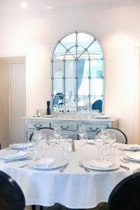 圣塞雷Le Victor Hugo - Hôtel et Restaurant - Logis Hôtels的一张桌子,上面有白色的桌布和镜子