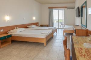 罗德岛卡利地亚Faliraki Dream Hotel的酒店客房设有两张床和一张桌子。