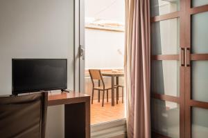 略夫雷加特河畔奥斯皮塔莱特马达尼斯里塞奥酒店的一间配有电视和一张桌子的房间,设有用餐室