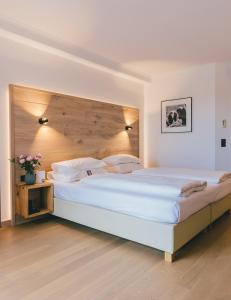 巴特塔茨曼斯多夫Hotel Reiters Finest Family的卧室配有一张白色大床和木制床头板