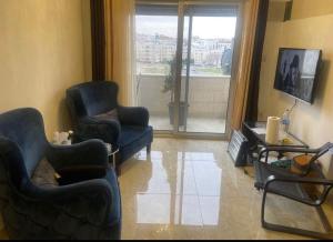 安曼Apartment in Amman 7th circle的客厅配有两把椅子和电视